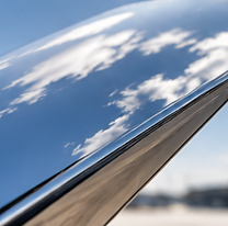 Polished aircraft surface reflecting the blue sky.