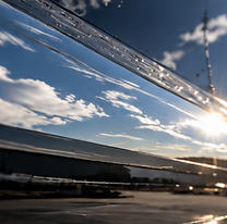 Glossy aircraft exterior reflecting clouds along the polished surface.